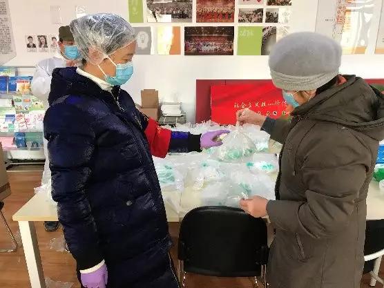 為樓棟分發(fā)口罩，并為包裝袋消毒